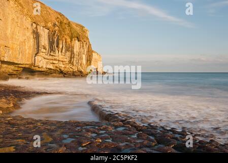 the rock ledge, waves and cliffs at Dancing Ledge on the Dorset coast close to Swanage on a fine sunny autumnal day Stock Photo