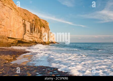 the rock ledge, waves and cliffs at Dancing Ledge on the Dorset coast close to Swanage on a fine sunny autumnal day Stock Photo