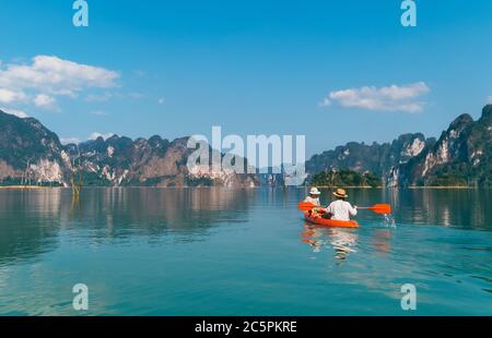 Mother and son floating on kayak together on Cheow Lan lake in Thailand. Traveling with kids concept image. Stock Photo