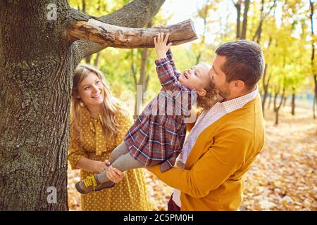 Happy family playing in the park in the fall. Stock Photo
