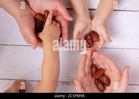 People holding dates fruits, kid takes dried fruits, flat lay Stock Photo