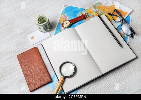 Ready for the trip. Map, blank book, magnifier, glasses, notebook, pencils, clock and money. Stock Photo