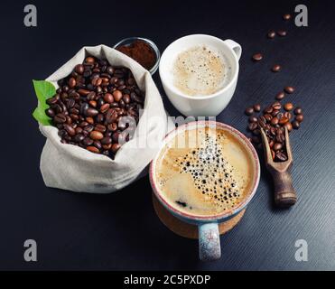 Coffee cups with coffee beans on black table background. Stock Photo