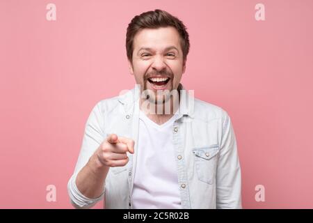 smiling man pointing fingers at camera, picking you Stock Photo