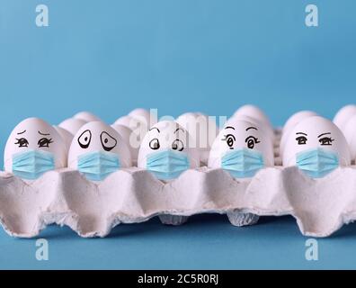 Faces on the eggs, eggs with face mask, corona virus epidemic concept Stock Photo
