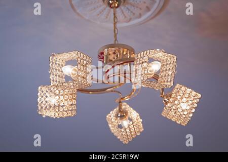 Chandelier Lamp beautiful luxury expensive chandelier hanging under ceiling . The lamp in the beautiful room . Brass chandelier with crystal Stock Photo