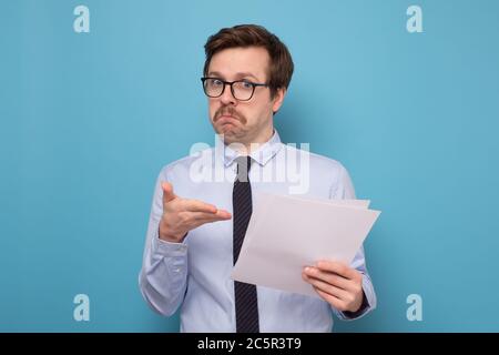 Satisfied young man with glasses checking documentation. Stock Photo