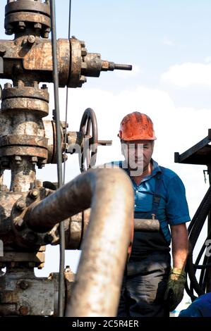 Worker man near the mouth of a gas well Stock Photo