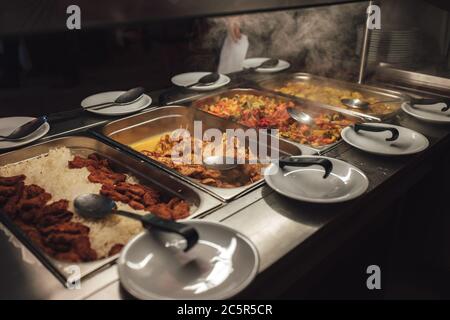 Stainless hotel pans on food warmers with various meals. Roasted meat  pieces with vegetable. Self-service buffet table. Celebration, party,  wedding Stock Photo - Alamy