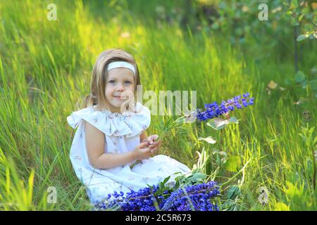 Portrait of a cute girl with lupine flowers in her hands Stock Photo