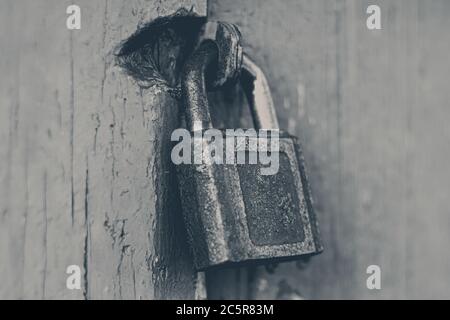 Old rusty cast iron padlock on red painted door Stock Photo