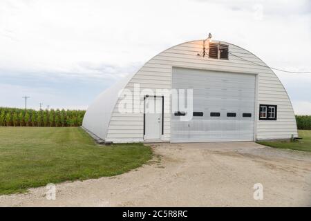 Quonset barn building made of corrugated metal and having a semicircular cross section. Stock Photo