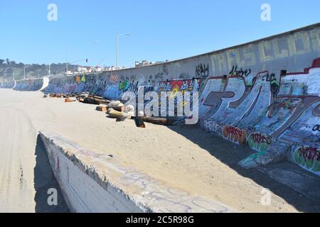Colourful graffiti  and driftwood along the sea wall on Ocean Beach, the Pacific Coast of San Francisco, California Stock Photo