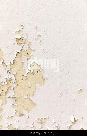 Old cracked peeling  white  paint on a neutral concrete surface. Stock Photo