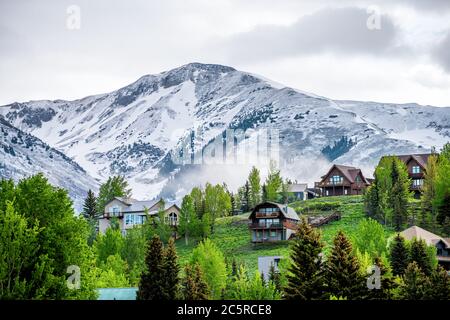 Crested Butte, USA Colorado village in summer with clouds and foggy mist morning and houses on hillside with green trees Stock Photo