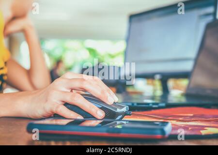 Hand women use computer mouse for working on the table. Stock Photo