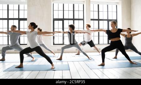 Young mixed race people standing in warrior II second position. Stock Photo