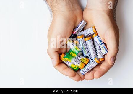 Men's hands hold batteries and used batteries on white background. Isolated.The recycling of batteries. collection and recycling of dangerous waste  Stock Photo