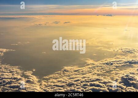 Beautiful sunrise sky above clouds with dramatic light. Cabin view from airplane Stock Photo