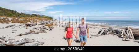 Panoramic banner of Couple walking on beach in New Zealand - people in Ship Creek on West Coast of New Zealand. Tourist couple sightseeing tramping on Stock Photo