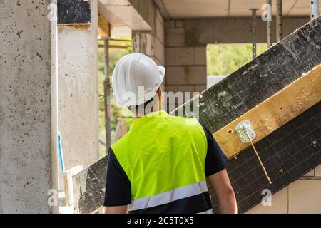 construction worker on building site, man in reflective vest and helmet Stock Photo