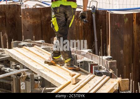 Construction worker on scaffolding on a large construction site Stock Photo