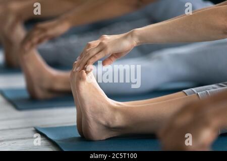 Close up group of diverse young people touching feet. Stock Photo