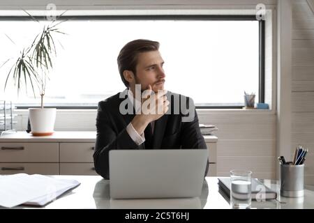 Pensive businessman distracted from computer work thinking in office Stock Photo