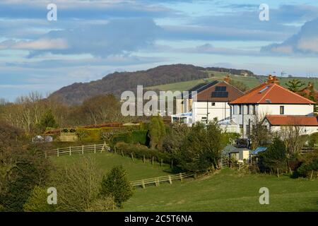 Semi-detached houses in scenic green leafy suburbs, farm fields & Otley Chevin (hillside woodland) - Menston village, West Yorkshire, England, UK. Stock Photo