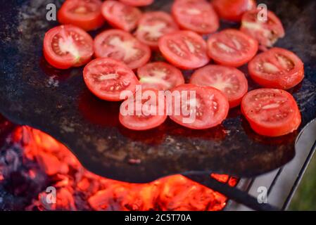 Grill tomato. Grilled vegetables. Tomatoes on a fire in a pan. Vegetables Stock Photo