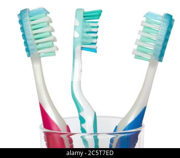 Three tooth brushes in glass. Isolated on white background. Clipping path. Stock Photo