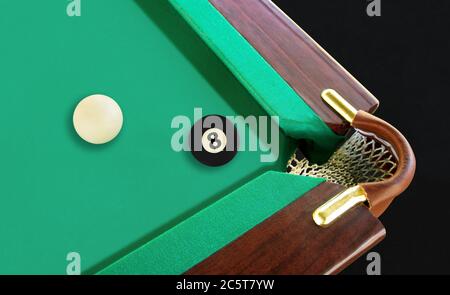 8 ball resting near the corner pocket Stock Photo