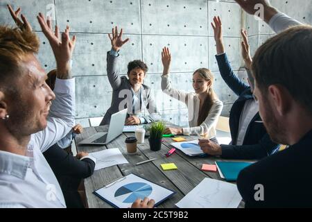 Business people at meeting raising hands, corporate cooperation success team concept, people working with financial data reports Stock Photo