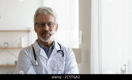Profile picture of elderly male doctor in white medical uniform Stock Photo