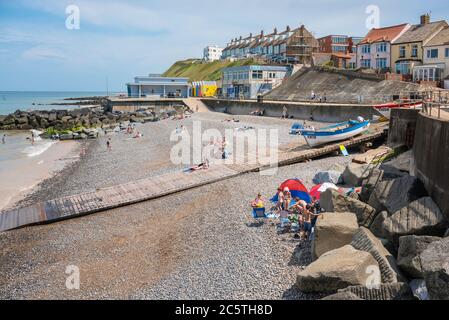 Sheringham beach Norfolk UK, view in summer of people sunbathing on Sheringham beach, north Norfolk, East Anglia, England, UK Stock Photo