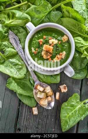 Spinach potage cream soup in bowl on rustic table Stock Photo