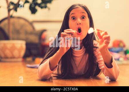 Girl playing with matches. Dangerous situation at home. A small child plays with matches, a fire, a fire flares up, danger, child and matches, lucifer Stock Photo