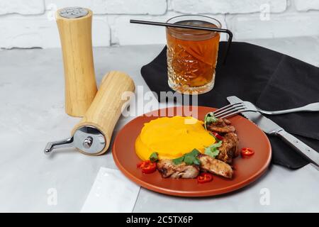 Grilled chicken skewers and pumpkin puree on a white plate Stock Photo