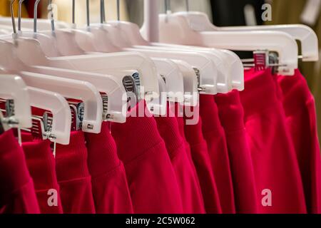 Stylish fashionable clothes on hangers in a store. Selective focus Stock Photo