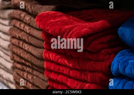 A stack of multi-colored bath towels close-up. Spa accessories for health care. Stock Photo