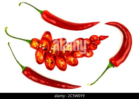 A few red hot peppers with one cut into pieces on a white background Stock Photo