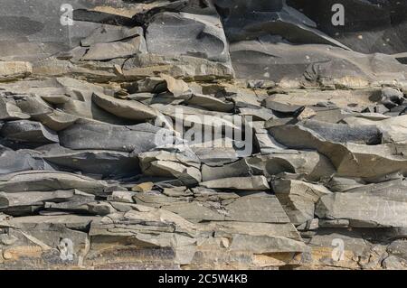 Texture of a dark gray granite stone or background for design. The surface of the stone from the texture surfaces for the tiles. Stock Photo