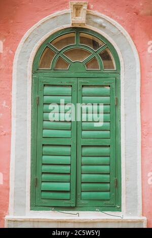 Vintage arched shutters, two panel rustic Mediterranean Shutter. Old wooden vintage louver window. Blinds Window Shutter Plantation Shutter in brown. Stock Photo