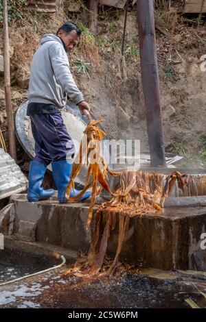 Bhutan, Thimphu, Jungshi Handmade Paper Factory. Factory worker boiling pulp used to make paper. Editorial only. Stock Photo