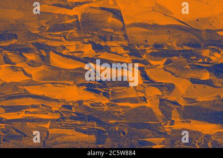 The surface of the rock with the texture of granite stone toned in purple and yellow tones. Designer background for interiors. Stone surface texture c Stock Photo