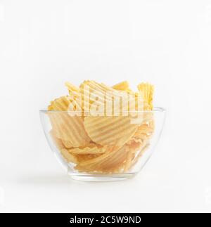 Ribbed chips in glass plate isolated on white background Stock Photo