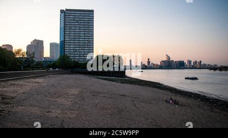 London, England, UK - June 26, 2010: Kelson House, a high rise council estate tower block, stands over Folly House Beach on the banks of the River Tha Stock Photo