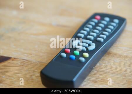 Black TV remote controller on wooden table Stock Photo