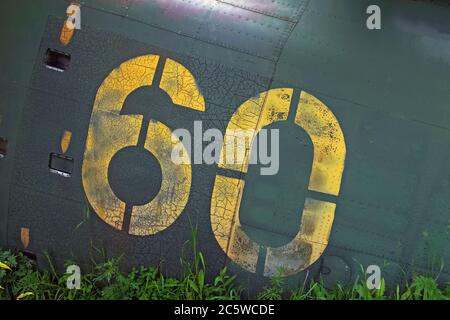 Number sixty painted with yellow paint on a weathered and rusted metal plate. Stock Photo