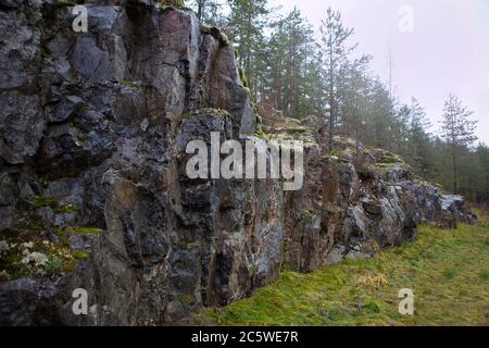 granite rock at the finland-Rocks with moss at the Forest. Large stones on green grass and rock face. Relief and texture of stone. Stone natural Stock Photo